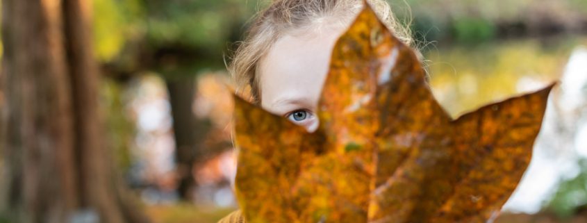 Groot herfstblad met meisje erachter